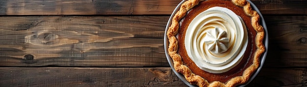 A contemporary setup of a pumpkin pie with a sleek spiral of whipped cream set on a polished dark wood table ambient light enhancing the golden hue of the pie ample space above