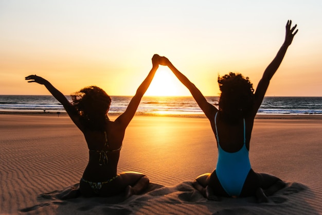 Content black woman on tropical beach at sunset