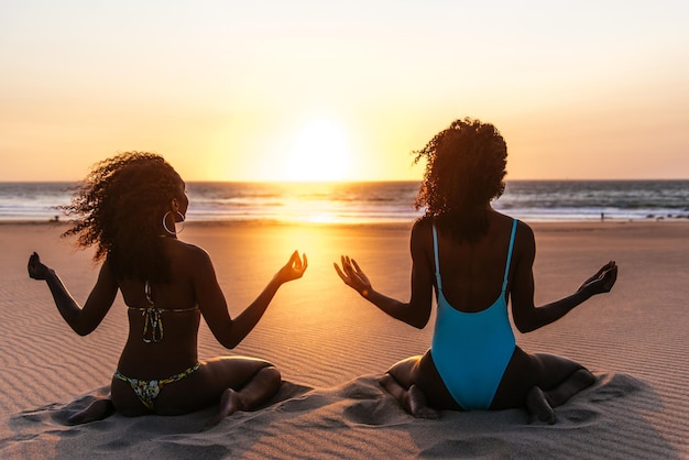 Content black woman on tropical beach at sunset