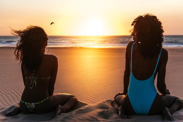 Content black woman on tropical beach at sunset