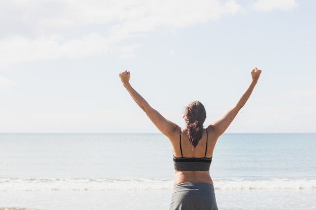 Content brunette woman standing on the beach