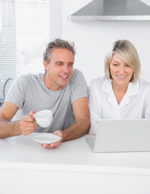 Content couple using laptop in the morning