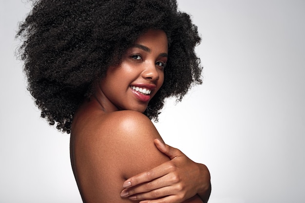 Content young black lady smiling at camera in studio