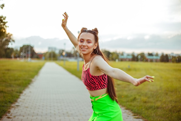 Content young woman in colorful hipster wear having fun in city street in summer 