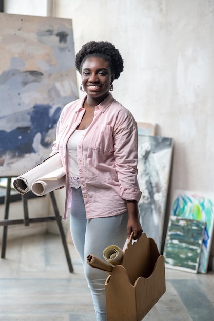 Contented african woman in pink clothes in the art studio