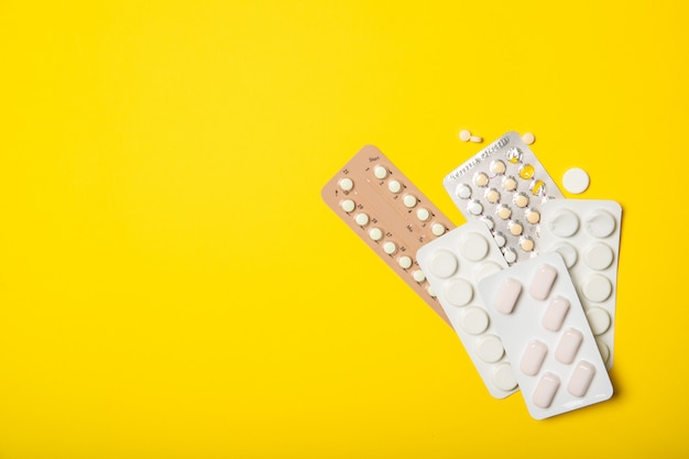 Contraceptive pill blisters on a yellow background