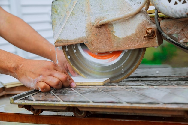 Contractor working on a tile saw the master cuts the tile on the saw