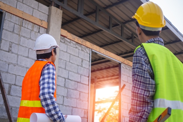 Contractors and engineers stand to talk and work together within the construction area