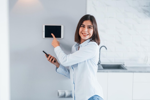 Controlling house by one touch Young woman is indoors in smart house room at daytime