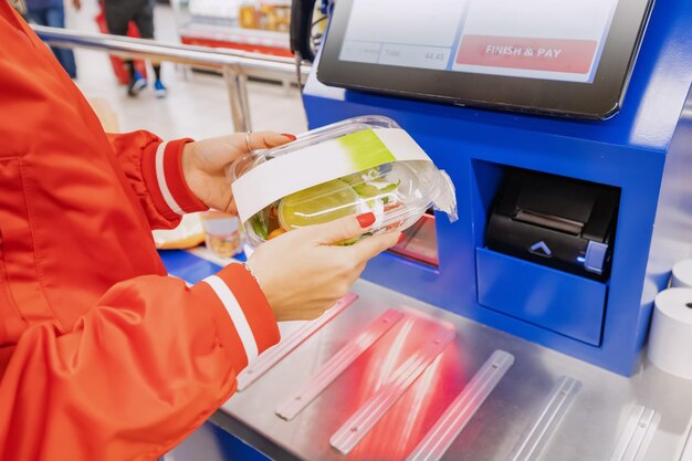 Convenience of a modern shopping as a customer scans their own items at the selfservice checkout in a bustling supermarket