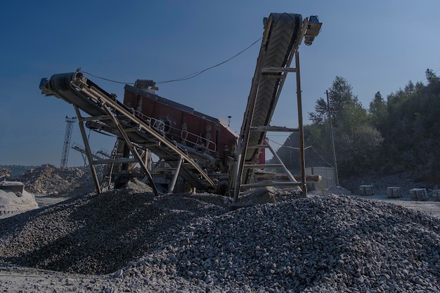 Conveyor belt at the quarry for the extraction and production of crushed stone on a summer day