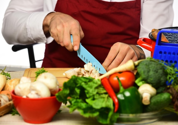 Cook burgundy uniform cuts vegetables Male hands cut mushroom