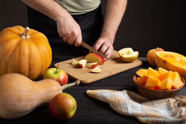 The cook cuts the apple into pieces for baking. 