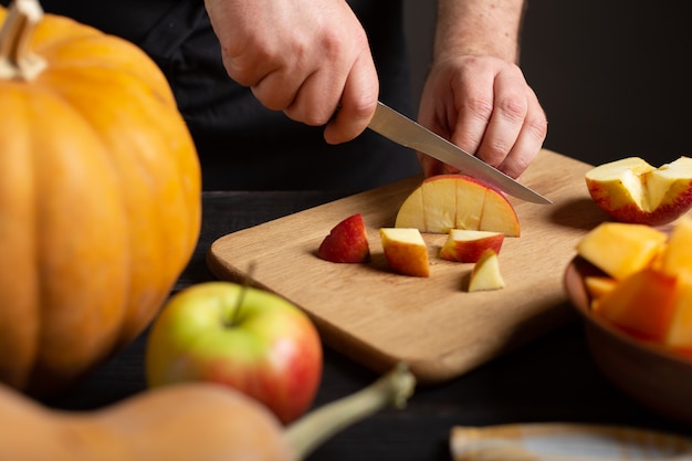 The cook cuts the apple into pieces for baking. 