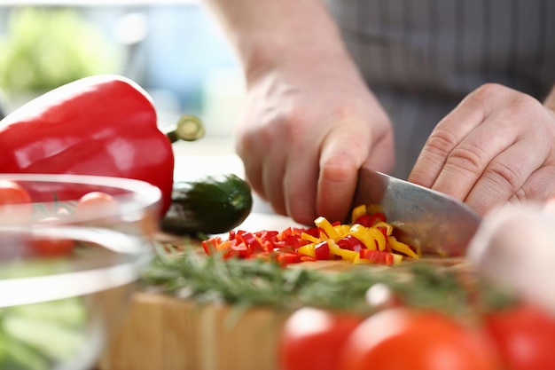 Cook cuts avegetable salad from fresh vegetables