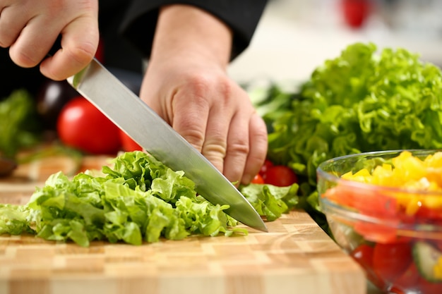 Cook holds knife in hand and cuts on