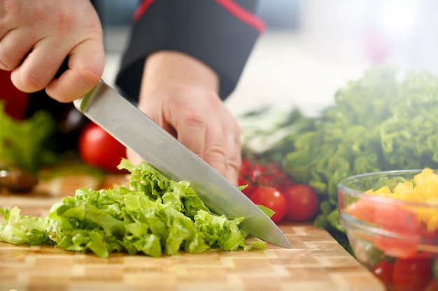 Cook holds knife in hand and cuts on