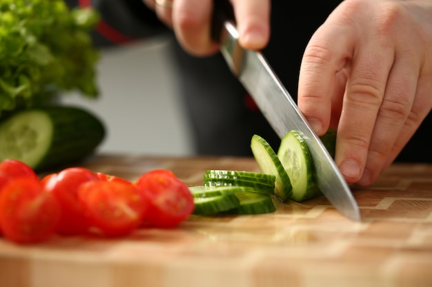 Cook holds knife in hand and cuts on