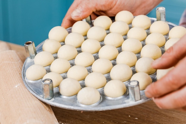 The cook in the kitchen makes dumplings The concept of cooking