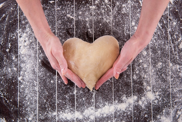 Cook preparing dough for baking in the kitchen