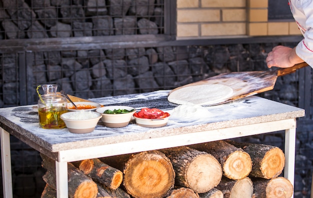 Cook preparing pizza in a restaurant.