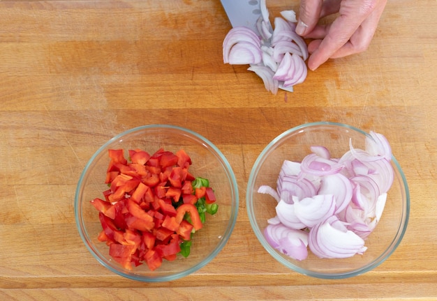 Cook's hand cutting vegetables on a chopping board Copy space