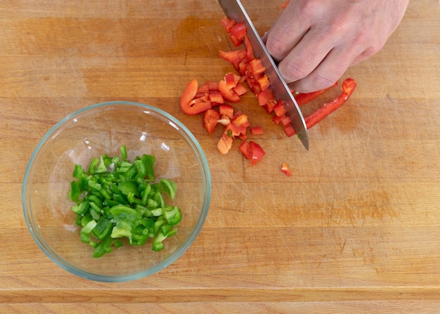 Cook's hand cutting vegetables on a chopping board Copy space