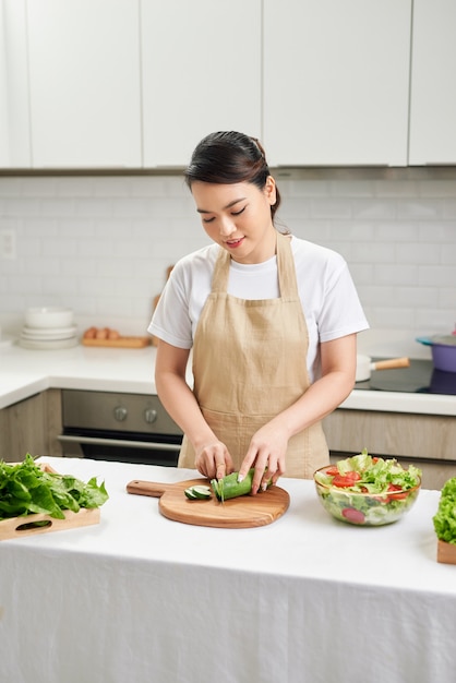 Cook Woman cuts vegetables in the kitchen