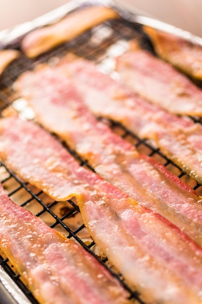 Cooked bacon strips on a baking sheet.