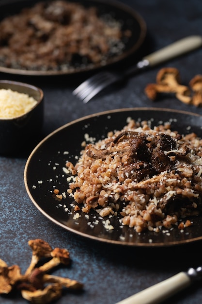 Cooked buckwheat with dried mushrooms on a plate sprinkled with Parmesan.