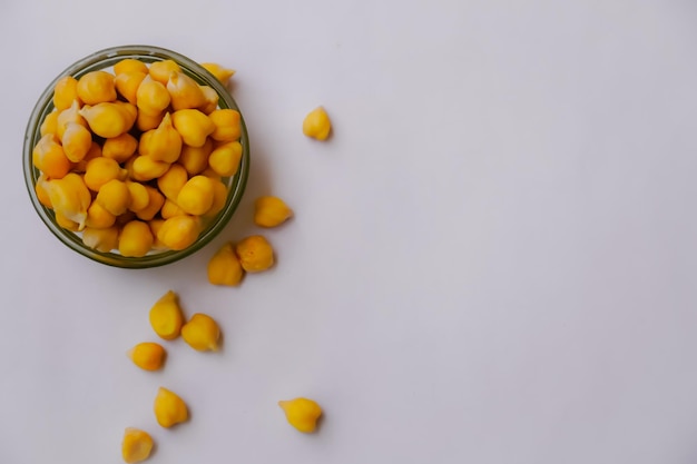 Cooked chickpeas in glass bowl isolated on white background. Spilled chickpeas