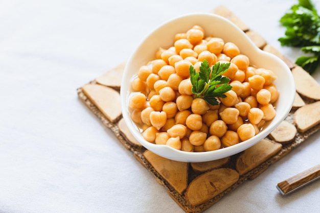 Cooked chickpeas in white bowl Ingredient for Tasty vegetarian food Boiled chickpeas selective focus