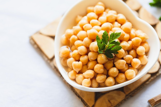 Cooked chickpeas in white bowl Ingredient for Tasty vegetarian food Boiled chickpeas selective focus