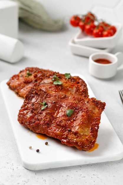 Cooked Marinated pork bbq ribs on ceramic white cutting board and white background