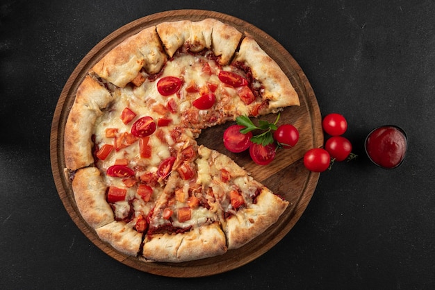 Cooked pizza with ingredients next to make tomato sauce mozzarella tomatoes olive oil cheese spices