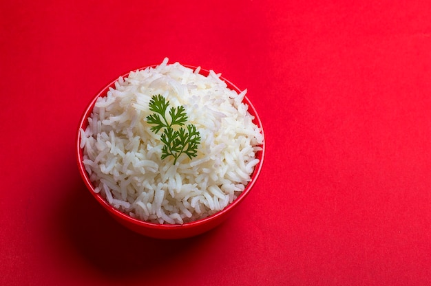 Cooked plain white basmati rice in a red bowl on red