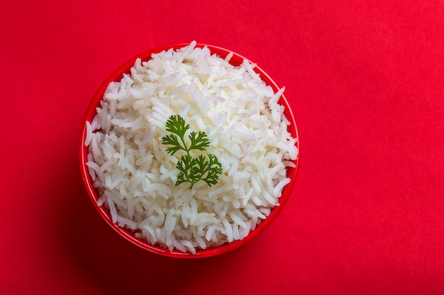 Cooked plain white basmati rice in a red bowl on red