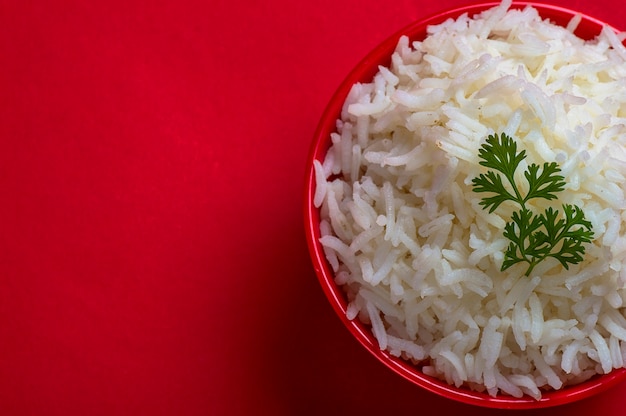 Cooked plain white basmati rice in a red bowl on red