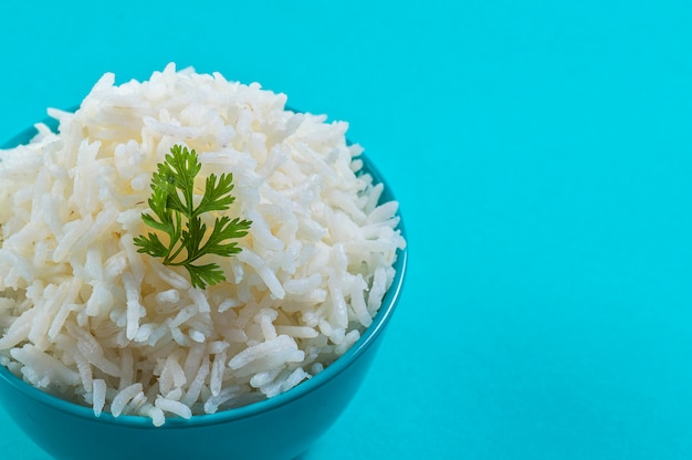 Cooked plain white basmati rice with corriander in a blue bowl