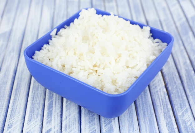 Cooked rice in bowl on wooden background