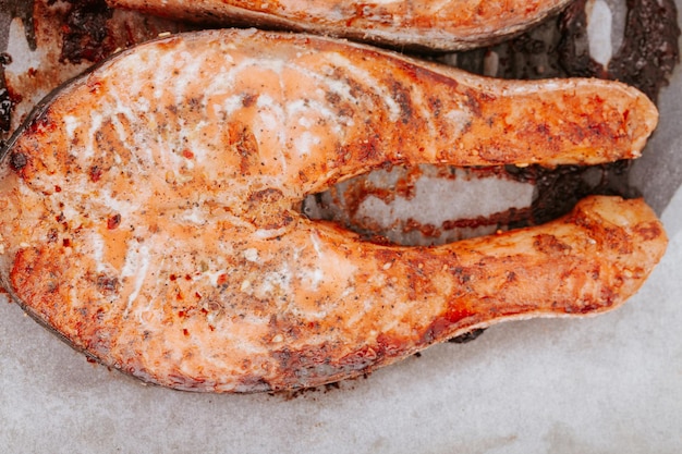 Cooked salmon steaks on a baking sheet close-up. Steaks of red fried fish. Pieces of baked salmon