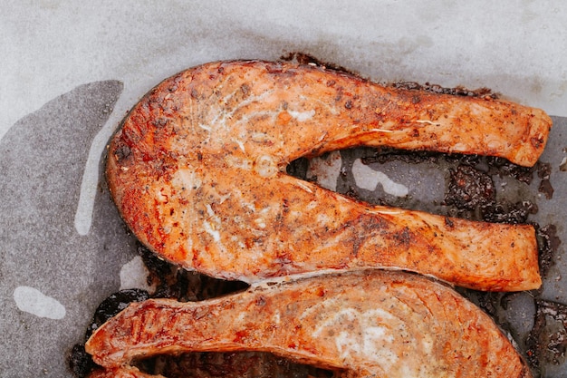 Cooked salmon steaks on a baking sheet close-up. Steaks of red fried fish. Pieces of baked salmon