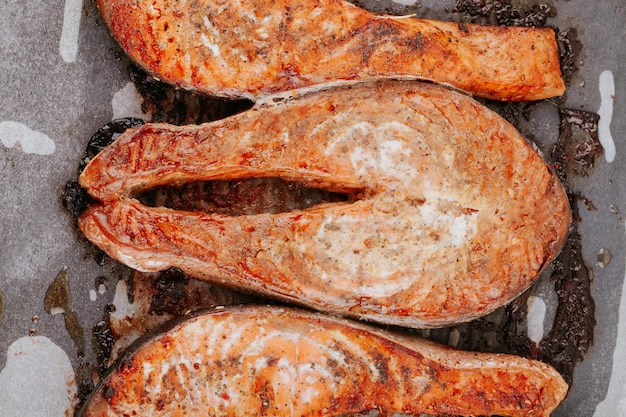 Cooked salmon steaks on a baking sheet close-up. Steaks of red fried fish. Pieces of baked salmon