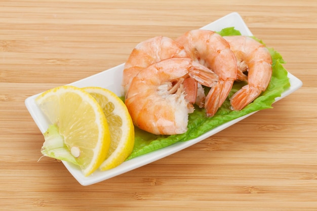 Cooked shrimps with lemon and salad leaves