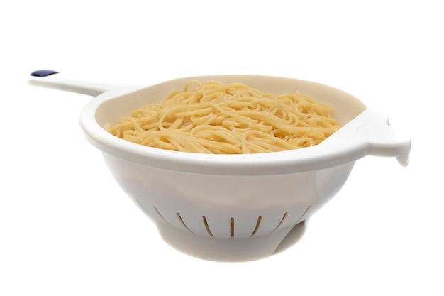 Cooked spaghetti in a colander, isolated on white background.