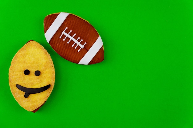 Cookie as an american football ball isolated on green background. Top view.