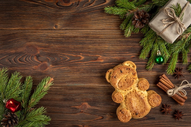 Cookie in the shape of a bear on wooden with Christmas balls