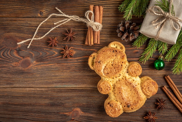 Cookie in the shape of a bear on wooden with Christmas balls