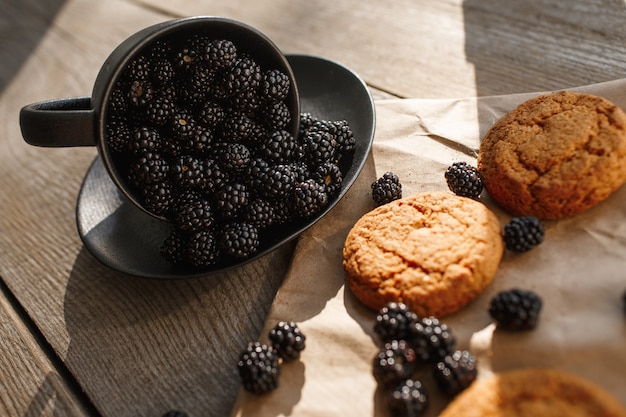 Cookies and blackberries on a wooden background