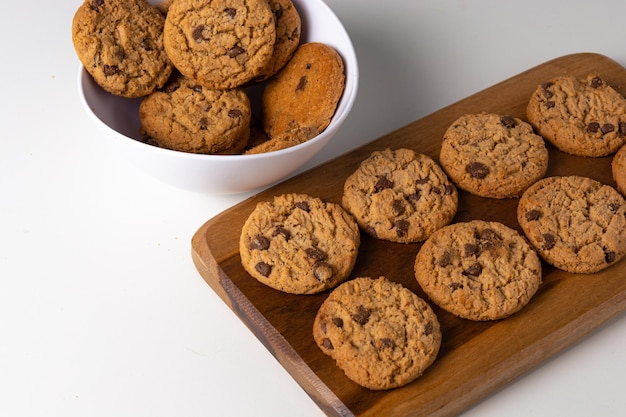 cookies on a cutting board and a white bowl over table